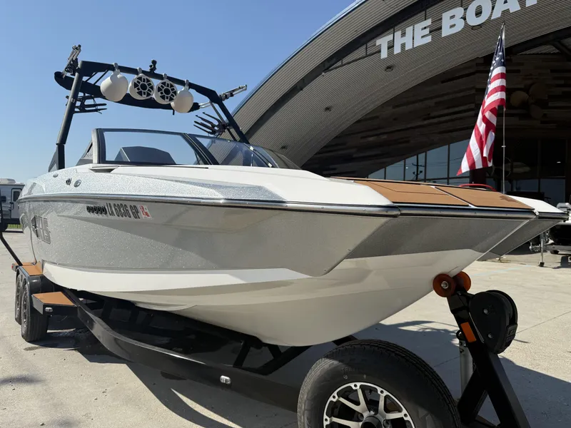 Slide: The Image of 2021 Axis A24 boat on trailer, displayed outside dealership with American flag. - 16