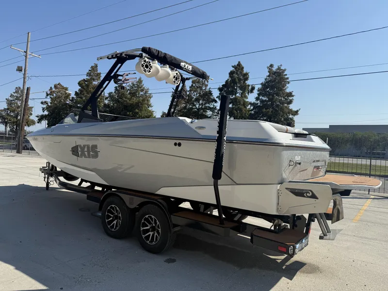 Slide: The Image of 2021 Axis A24 boat on trailer, parked outdoors under clear sky. - 6