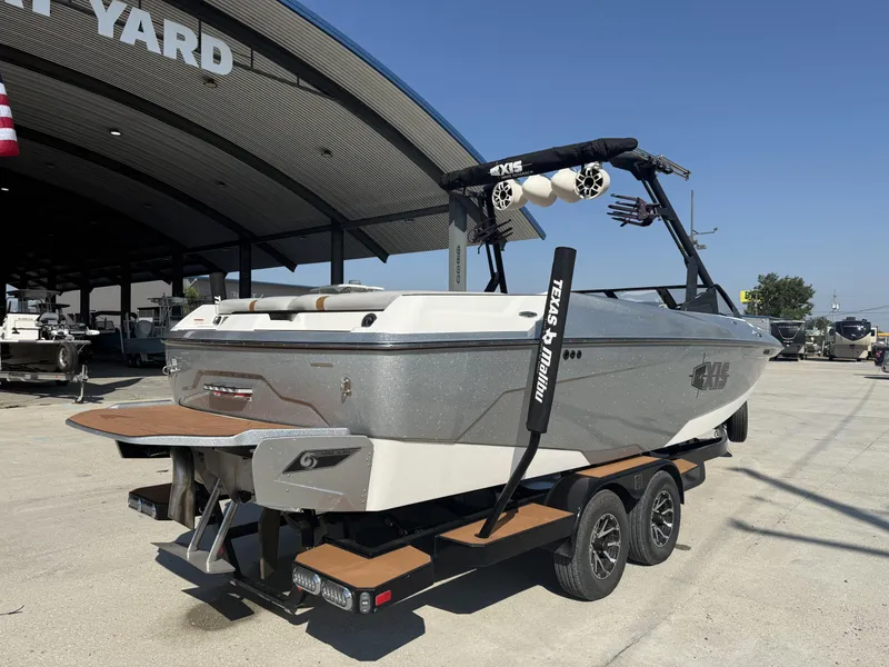 Slide: The Image of 2021 Axis A24 boat on trailer at dealership, under a large canopy. - 9