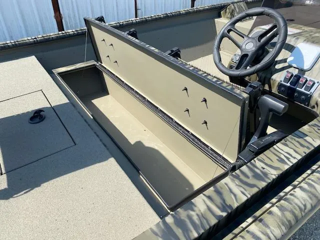 Slide: The Image of 2025 SeaArk Shadow 18 boat interior with open storage compartment and steering wheel. - 12