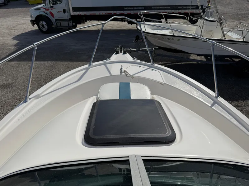 Slide: The Image of 1998 Bayliner 2052 Trophy Walkaround boat deck with hatch and railing, parked in a lot. - 10