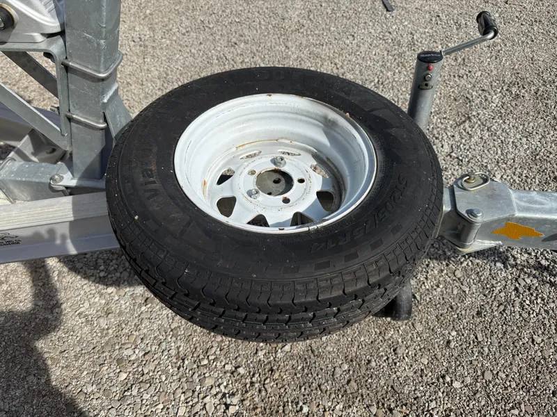 Slide: The Image of Trailer wheel for 1998 Bayliner 2052 Trophy Walkaround on gravel surface. - 12