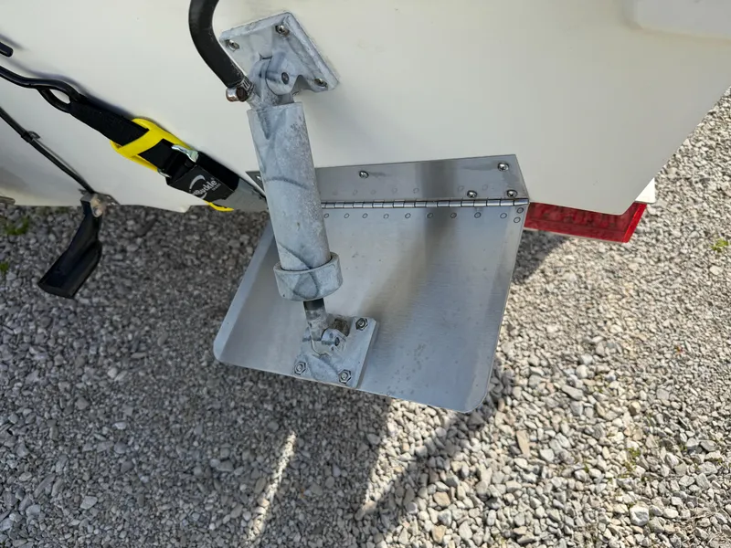 Slide: The Image of Trim tab on a 1998 Bayliner 2052 Trophy Walkaround boat, resting on gravel. - 17