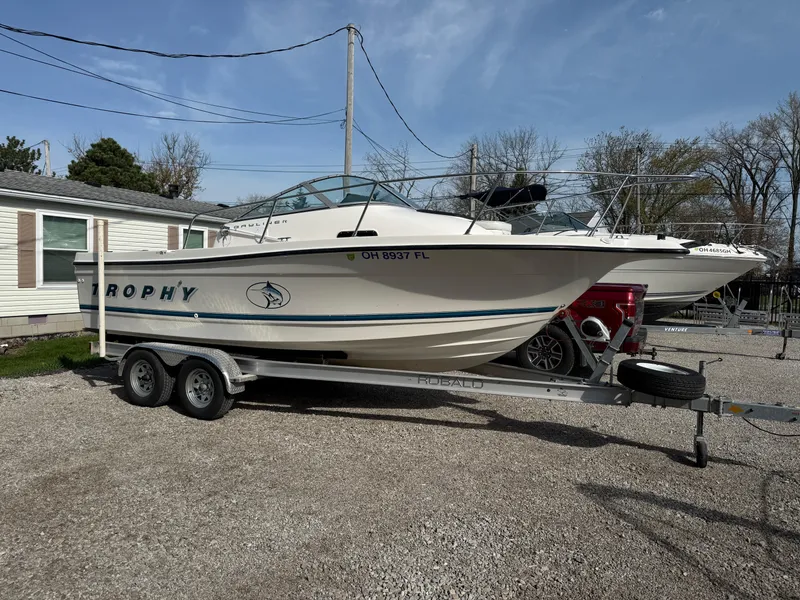 Slide: The Image of 1998 Bayliner 2052 Trophy Walkaround boat on trailer, parked outdoors. - 23