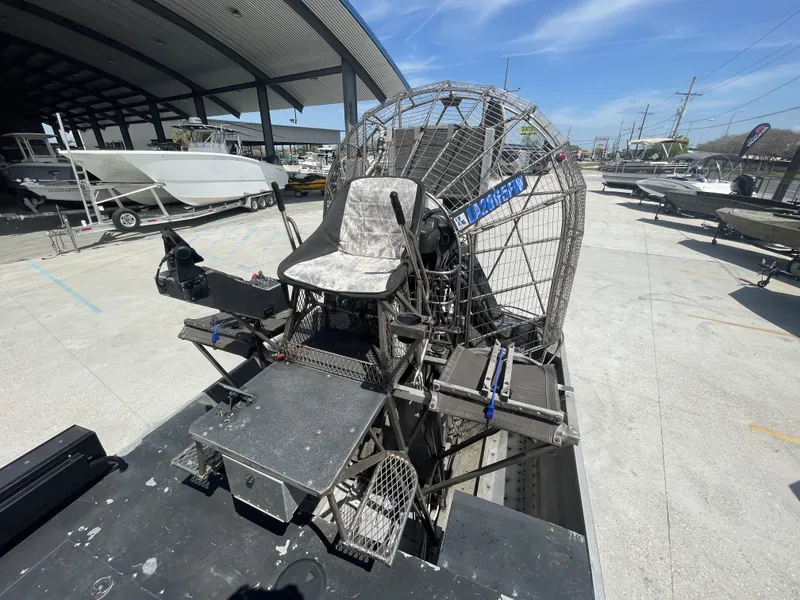Slide: The Image of 2008 Custom Alumitech 20 Airboat parked in a marina, showcasing its seating and fan structure. - 4