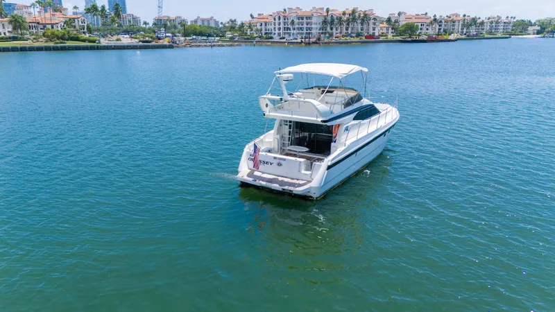 Slide: The Image of Azimut 43 Fly yacht from 1998 on calm water near luxury waterfront homes. - 13