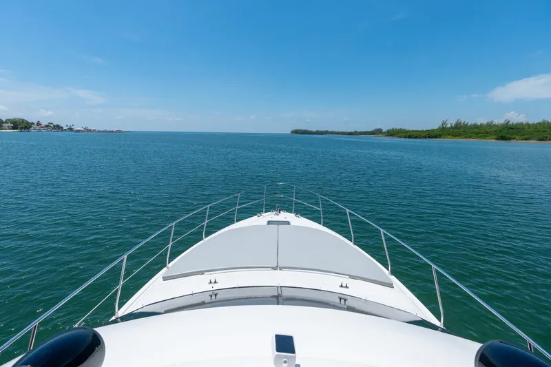 Slide: The Image of Bow view of 1998 Azimut 43 Fly yacht cruising on open water. - 25