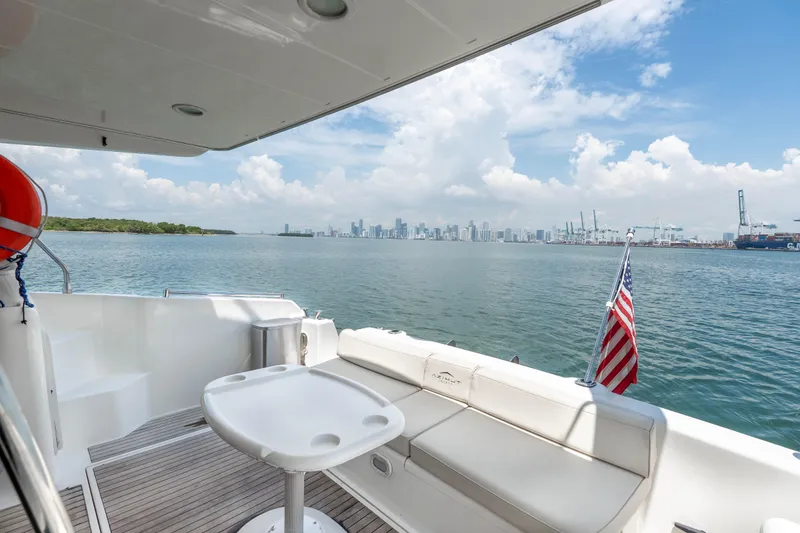 Slide: The Image of Azimut 43 Fly yacht deck with ocean view, American flag, and city skyline in background. - 28