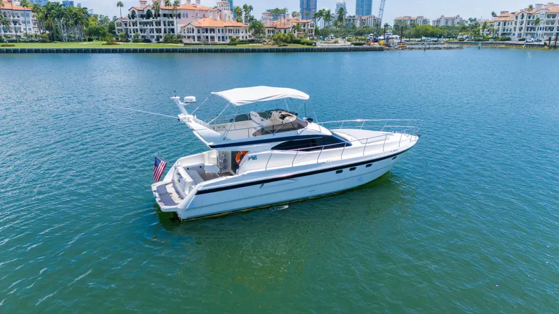 Slide: The Image of Azimut 43 Fly 1998 yacht cruising on a serene waterway with luxury waterfront homes. - 3