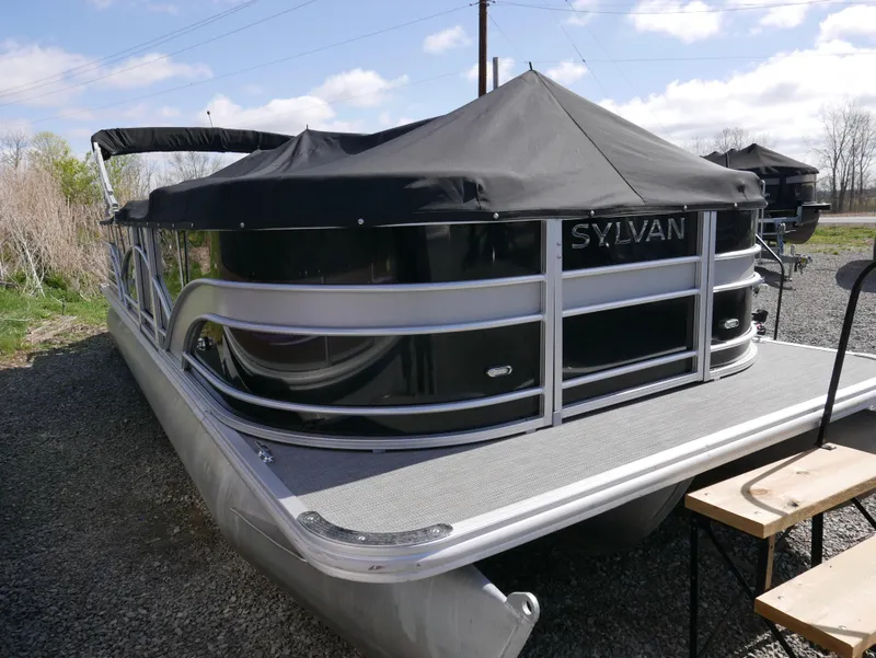 Slide: The Image of 2017 Sylvan 8522 Mirage Cruise pontoon boat with black cover, parked outdoors. - 3