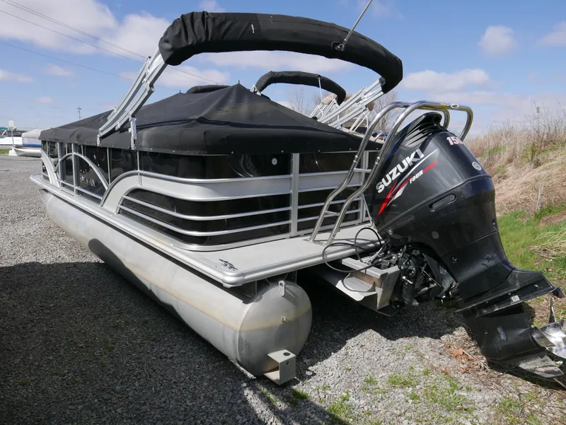 Slide: The Image of 2017 Sylvan 8522 Mirage Cruise pontoon boat with Suzuki outboard motor, parked on gravel. - 4