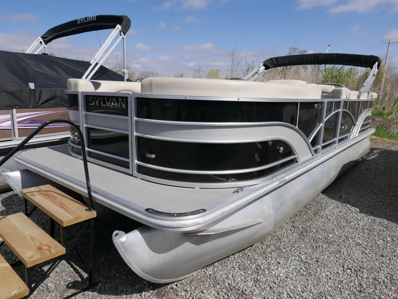 Slide: The Image of 2017 Sylvan 8522 Mirage Cruise pontoon boat on gravel, featuring sleek design and comfortable seating. - 6