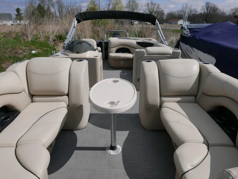 Slide: The Image of 2017 Sylvan 8522 Mirage Cruise pontoon boat with beige seating and central table. - 7
