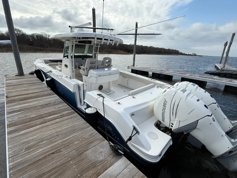 Slide: The Image of 2018 Boston Whaler 330 Outrage docked, featuring twin Mercury outboard engines. - 3