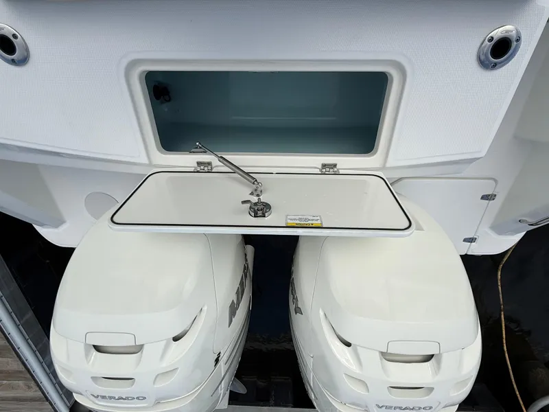 Slide: The Image of 2018 Boston Whaler 330 Outrage with dual outboard engines and open storage compartment. - 4
