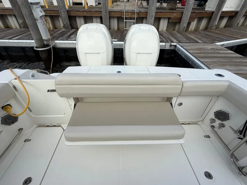 Slide: The Image of 2018 Boston Whaler 330 Outrage boat with dual engines and cushioned seating at dock. - 5