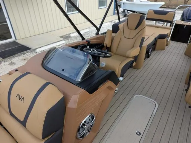 Slide: The Image of 2025 Avalon Catalina Quad Lounger 23 FT boat interior with tan and black seating. - 12
