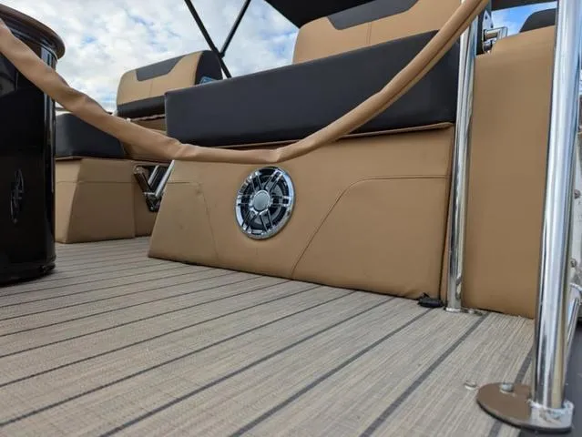 Slide: The Image of 2025 Avalon Catalina Quad Lounger 23 FT interior with beige seating and speaker detail. - 30
