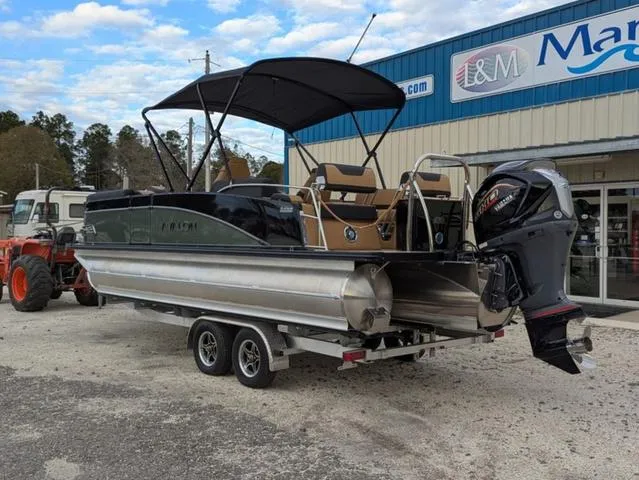 Slide: The Image of 2025 Avalon Catalina Quad Lounger 23 FT pontoon boat on trailer, parked outside dealership. - 4