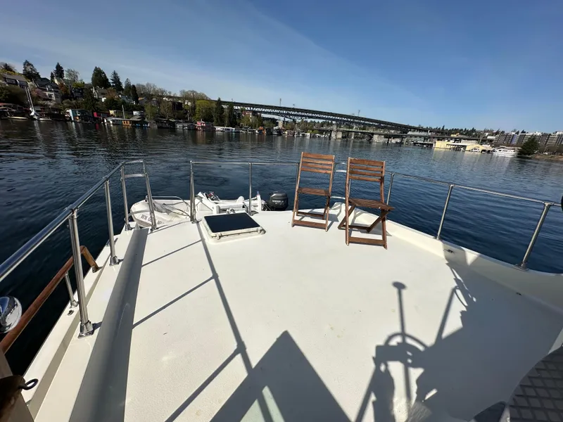 Slide: The Image of 1982 Tollycraft Tri Cabin boat deck with chairs, overlooking a serene waterfront view. - 12