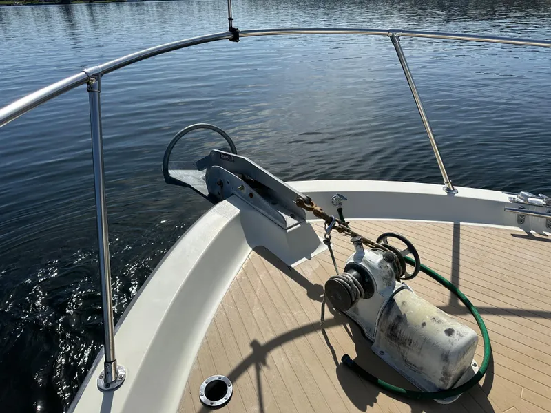 Slide: The Image of 1982 Tollycraft Tri Cabin boat deck with anchor and winch system on calm water. - 19