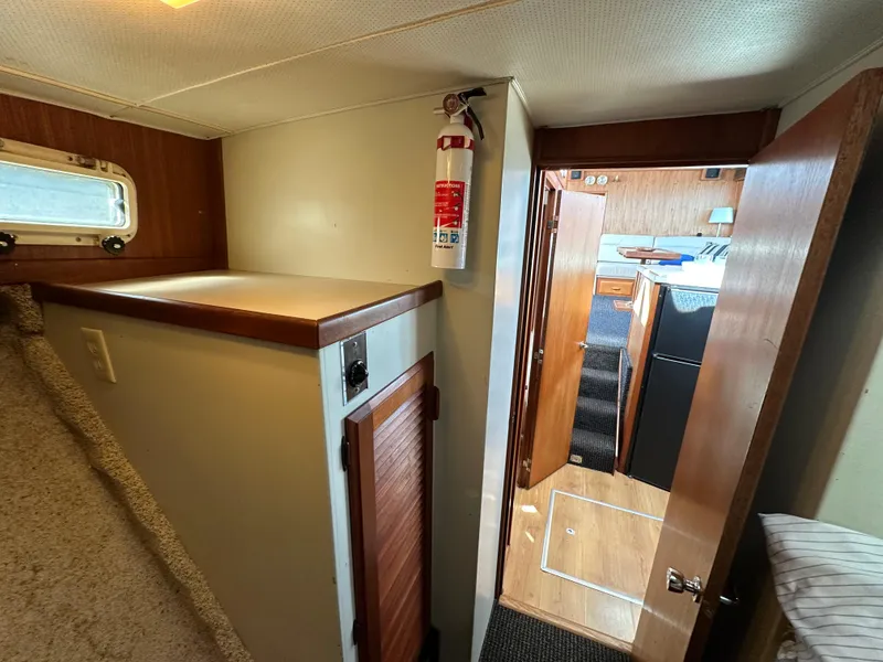 Slide: The Image of 1982 Tollycraft Tri Cabin interior with wood accents and fire extinguisher. - 48