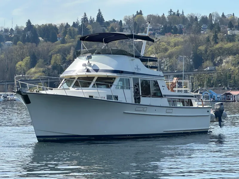Slide: The Image of 1982 Tollycraft Tri Cabin yacht on calm water with scenic forested background. - 6