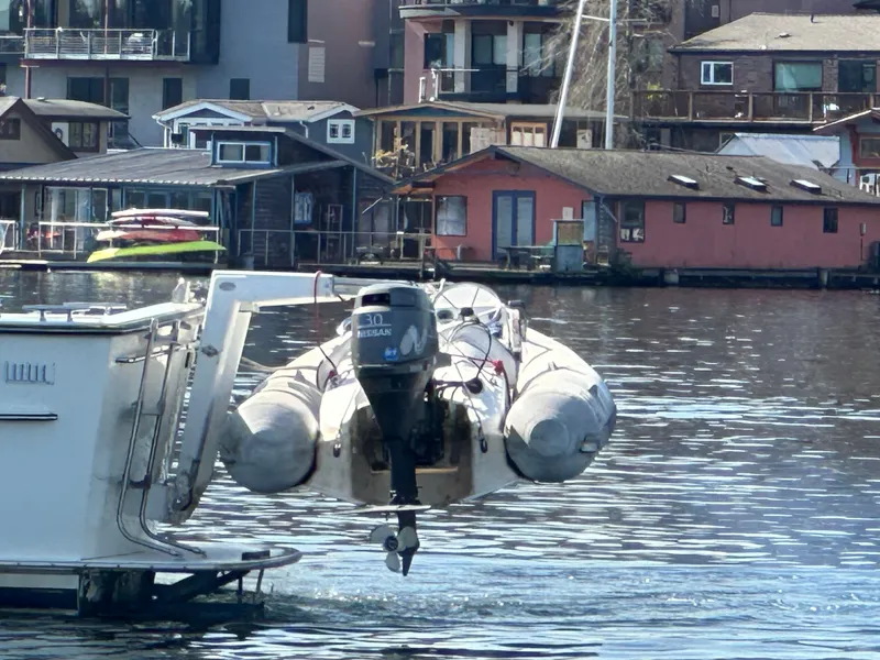 Slide: The Image of 1982 Tollycraft Tri Cabin with dinghy, docked near waterfront homes. - 9