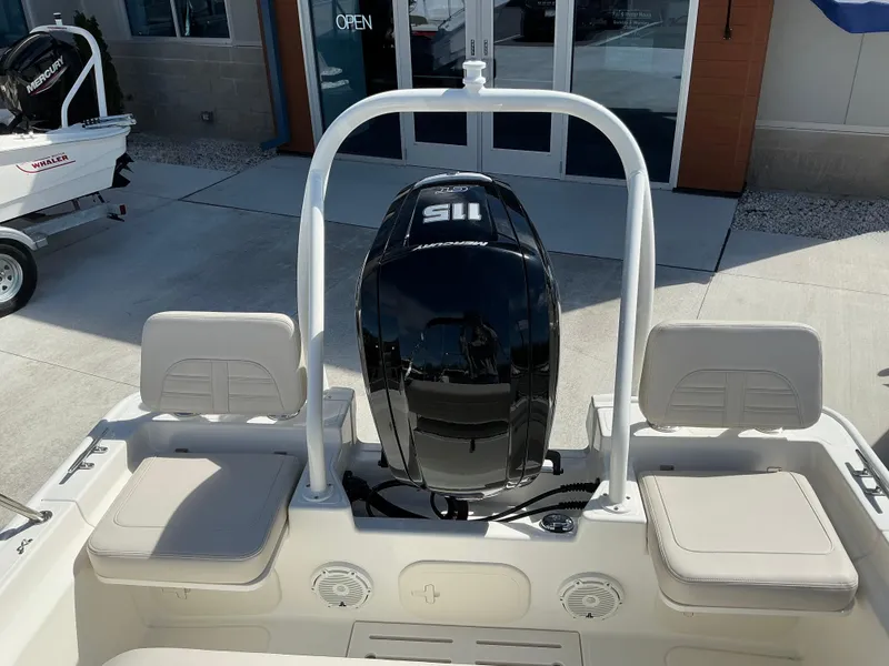 Slide: The Image of 2025 Boston Whaler 170 Montauk boat with Mercury engine, docked outside showroom. - 3