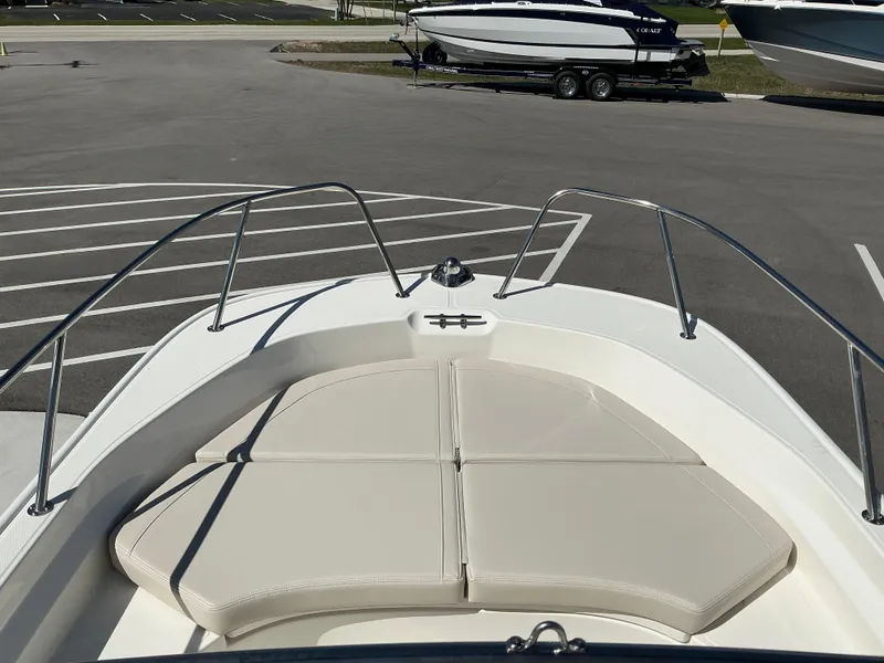 Slide: The Image of 2025 Boston Whaler 170 Montauk boat with cushioned bow seating in a parking lot. - 6