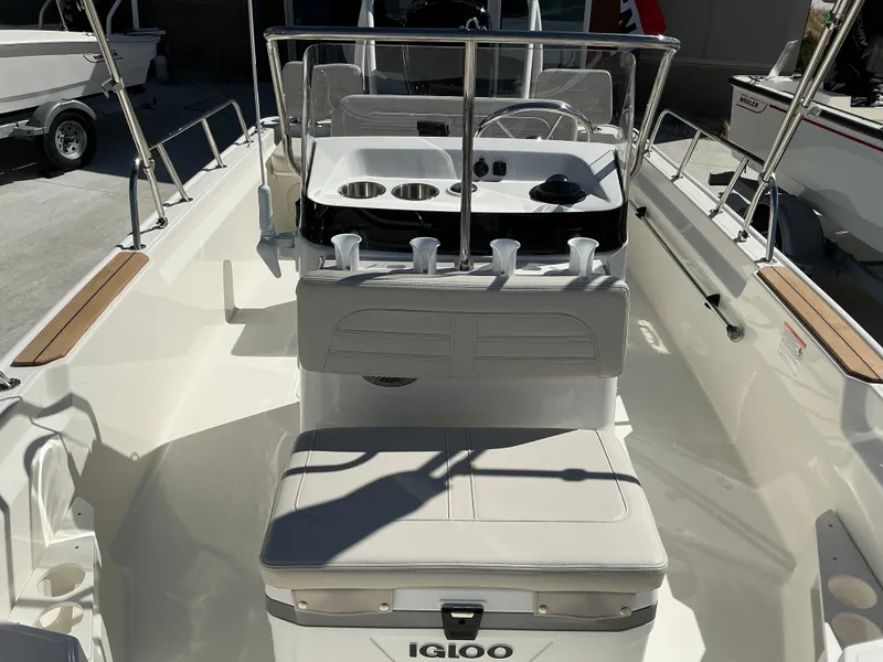 Slide: The Image of 2025 Boston Whaler 170 Montauk interior with seating and console, featuring Igloo cooler. - 7
