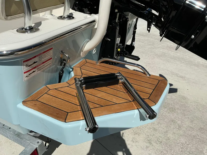 Slide: The Image of 2025 Boston Whaler 170 Montauk swim platform with teak finish and stainless steel ladder. - 9