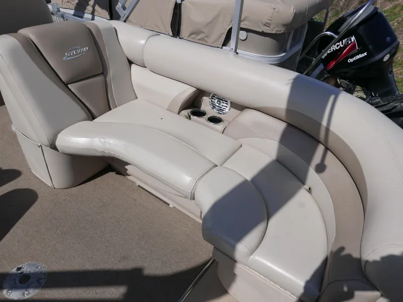 Slide: The Image of 2012 Sylvan Mirage 8522 LZ boat interior with beige seating and cup holders. - 15