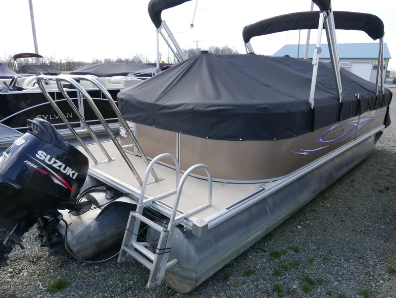 Slide: The Image of 2012 Sylvan Mirage 8522 LZ pontoon boat with Suzuki outboard motor, covered and docked. - 3