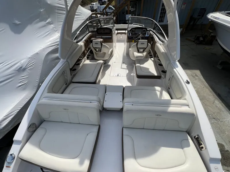 Slide: The Image of 2014 Chaparral 257 SSX boat interior with white leather seating and modern dashboard. - 4