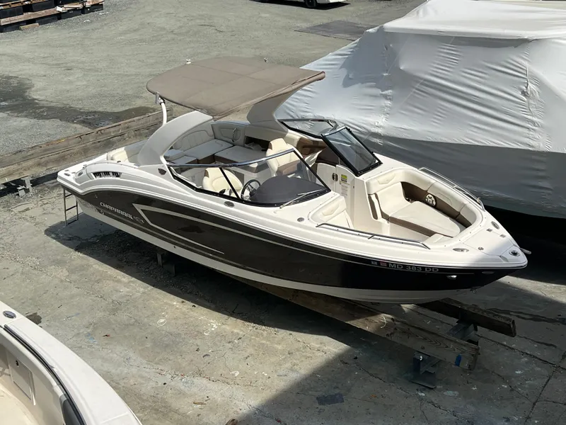 Slide: The Image of 2014 Chaparral 257 SSX boat with canopy, docked on a concrete surface. - 6