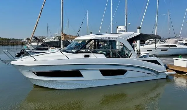 Slide: The Image of 2024 Beneteau Antares 9 boat docked in marina, sleek design, white exterior. - 0