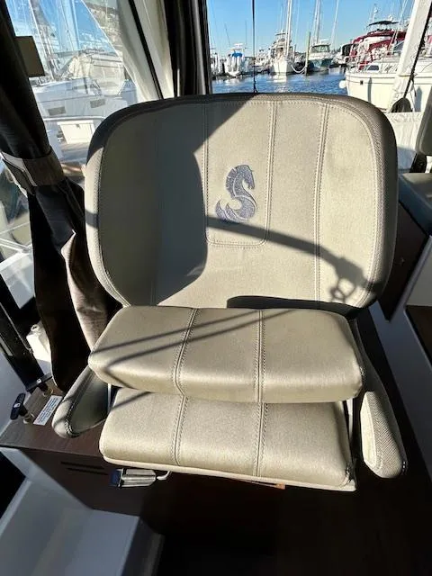 Slide: The Image of Captain's chair on 2024 Beneteau Antares 9 boat, featuring embroidered logo, docked at marina. - 20
