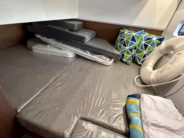 Slide: The Image of 2024 Beneteau Antares 9 cabin with cushions, pillows, and a life preserver. - 29