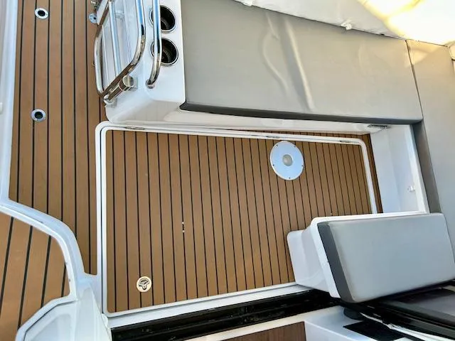 Slide: The Image of 2024 Beneteau Antares 9 boat deck with cushioned seating and wood finish. - 6