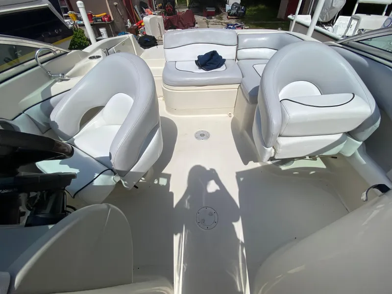Slide: The Image of 2006 Sea Ray 220 Sundeck interior with white seating and steering wheel. - 6