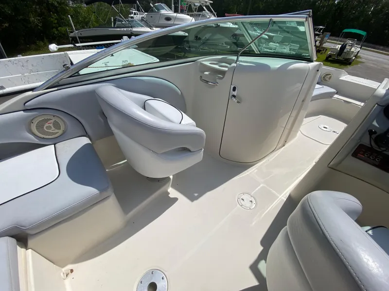 Slide: The Image of 2006 Sea Ray 220 Sundeck interior with white seating and steering console. - 9