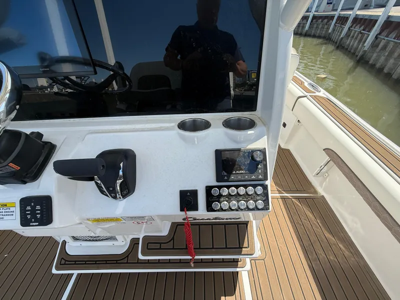 Slide: The Image of Control panel of 2025 Tidewater 2500 Carolina Bay boat with steering and switches. - 2