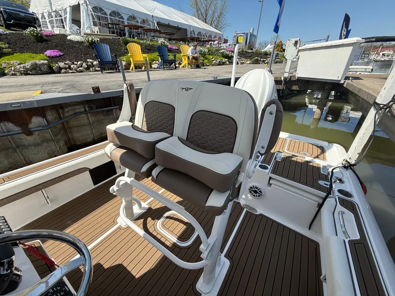 Slide: The Image of 2025 Tidewater 2500 Carolina Bay boat interior with dual seats at a marina. - 7