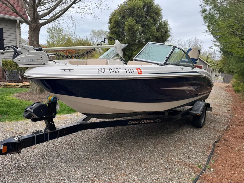 Slide: The Image of 2013 Chaparral 19 Sport H2O boat on trailer, parked on gravel driveway. - 2