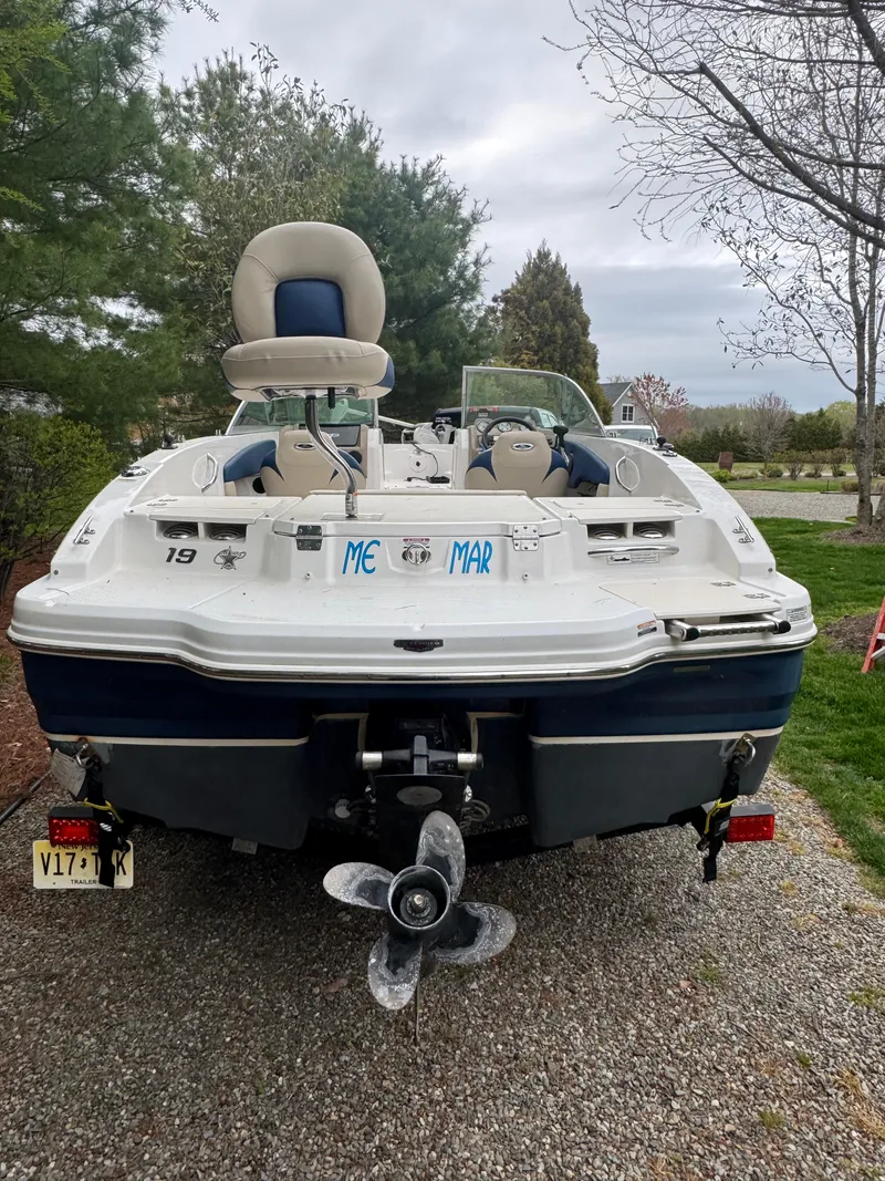 Slide: The Image of 2013 Chaparral 19 Sport H2O boat on gravel, surrounded by trees. - 4
