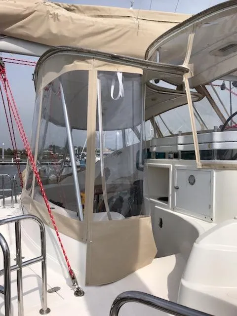 Slide: The Image of 2009 Prout 45S yacht with beige canopy and clear panels, docked at a marina. - 41