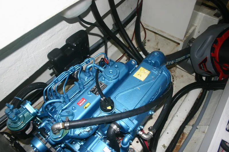 Slide: The Image of Engine compartment of a 2009 Prout 45S, featuring a blue marine engine with visible wiring. - 48