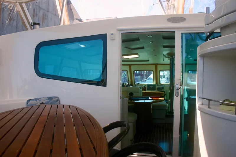 Slide: The Image of 2009 Prout 45S yacht interior with wooden table and sliding glass door. - 6