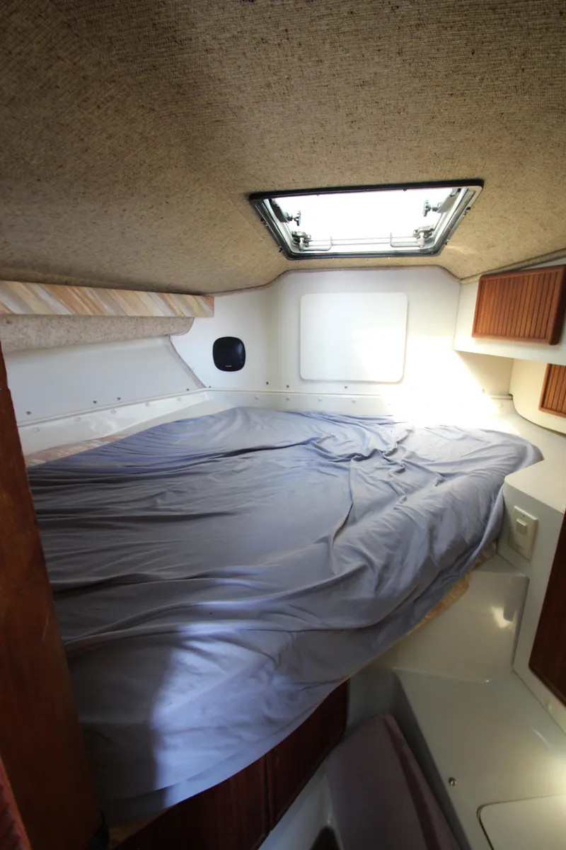 Slide: The Image of 1990 Boston Whaler 31 Sportfisherman cabin interior with bed and overhead hatch. - 12